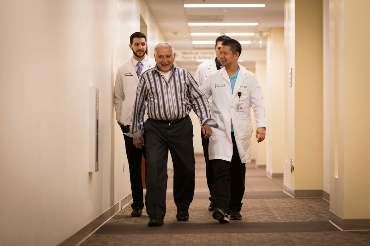 Doctors and patient walking down hall